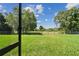 Backyard featuring a large, well-maintained lawn surrounded by a metal fence and mature trees at 12020 66Th Ave, Seminole, FL 33772