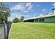 Spacious backyard featuring lush green grass, surrounded by a fence and trees with patio view at 12020 66Th Ave, Seminole, FL 33772