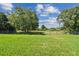 Large, green backyard with a metal fence surrounding the perimeter and mature trees visible at 12020 66Th Ave, Seminole, FL 33772
