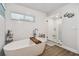 Bright bathroom showcasing a soaking tub and glass-enclosed shower with stylish tile accents at 12020 66Th Ave, Seminole, FL 33772
