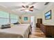 Bedroom with twin beds, wood floors, ceiling fan, and dresser at 12020 66Th Ave, Seminole, FL 33772