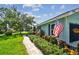 Charming home exterior with lush landscaping and an American flag adorning the side near the walkway at 12020 66Th Ave, Seminole, FL 33772