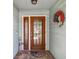 Close-up of the charming front door with glass panels, decorative wreath, and welcome mat at 12020 66Th Ave, Seminole, FL 33772