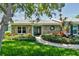 Charming single-story home with stone facade, lush landscaping and a beautiful walkway to the front door at 12020 66Th Ave, Seminole, FL 33772