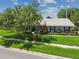 Charming home with well-manicured front lawn, mature tree, and colorful landscaping at 12020 66Th Ave, Seminole, FL 33772