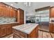 Kitchen with center island, stainless steel refrigerator, granite countertops, and wood cabinets at 12020 66Th Ave, Seminole, FL 33772