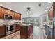 Spacious kitchen featuring an island, wood cabinets, granite countertops, and stainless steel appliances at 12020 66Th Ave, Seminole, FL 33772