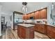 Kitchen with center island, stainless steel refrigerator and appliances, granite countertops, and wood cabinets at 12020 66Th Ave, Seminole, FL 33772