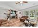 Comfortable living room features hardwood floors, a ceiling fan, and a decorative fireplace with mounted TV at 12020 66Th Ave, Seminole, FL 33772
