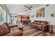 An open living room showcases hardwood floors, a ceiling fan, an open concept kitchen, and stylish artwork at 12020 66Th Ave, Seminole, FL 33772