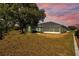 Expansive backyard view showcasing a screened-in patio and mature trees, perfect for outdoor living at 1247 Venetia Dr, Spring Hill, FL 34608