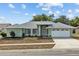 Charming single-story home with a well-maintained lawn, two car garage, and a quaint, welcoming entrance at 1247 Venetia Dr, Spring Hill, FL 34608