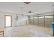 Spacious two-car garage with concrete flooring, side entry door, and automatic door opener system at 1247 Venetia Dr, Spring Hill, FL 34608