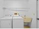 A laundry room with appliances, a utility sink and storage shelf at 1247 Venetia Dr, Spring Hill, FL 34608