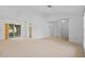 Spacious living room with neutral carpet, sliding glass doors to the outside, and bright lighting at 1247 Venetia Dr, Spring Hill, FL 34608