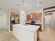 Bright kitchen with large marble island, stainless appliances, wooden cabinets, and access to hallway at 12620 Flatwood Creek Dr, Gibsonton, FL 33534