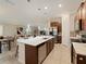 Open-concept kitchen features a large island with seating, stainless steel appliances, and dark wood cabinetry at 12620 Flatwood Creek Dr, Gibsonton, FL 33534