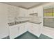 Enclosed outdoor kitchenette featuring white cabinets, mosaic backsplash and granite countertops at 12620 Flatwood Creek Dr, Gibsonton, FL 33534