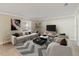 Modern living room with neutral furniture, a large TV, and a gray patterned rug at 12620 Flatwood Creek Dr, Gibsonton, FL 33534