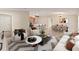 Bright, open-concept living room with modern furniture and neutral color palette adjacent to kitchen and dining area at 12620 Flatwood Creek Dr, Gibsonton, FL 33534