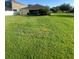 Green backyard featuring a well-maintained lawn and a cozy covered patio at 13181 Royal Pines Ave, Riverview, FL 33579