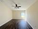 The bedroom has a ceiling fan and one sunlit window with wood-look floors at 13181 Royal Pines Ave, Riverview, FL 33579