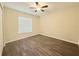 Cozy bedroom with wood-look flooring, a ceiling fan, and a bright window at 13181 Royal Pines Ave, Riverview, FL 33579
