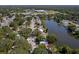 Aerial view of a residential home near a serene lake in a leafy neighborhood at 1393 Chesterfield Dr, Dunedin, FL 34698