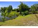 Picturesque backyard with lush greenery, a serene pond, and cozy seating area at 1393 Chesterfield Dr, Dunedin, FL 34698