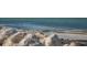 Scenic beach view with clear turquoise water and a sandy shore near waterfront properties at 1393 Chesterfield Dr, Dunedin, FL 34698