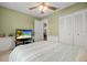 Relaxing bedroom with green walls features ceiling fan, closet, television and comfortable bed  at 1393 Chesterfield Dr, Dunedin, FL 34698