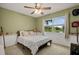 Sunlit bedroom overlooking a lake with green walls features ceiling fan, closet, and comfortable bed  at 1393 Chesterfield Dr, Dunedin, FL 34698