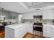Bright kitchen features white cabinets, stainless steel appliances, and an eat-in dining area at 1393 Chesterfield Dr, Dunedin, FL 34698