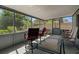 Bright, screened-in porch with seating area, perfect for enjoying the outdoors in comfort at 1393 Chesterfield Dr, Dunedin, FL 34698