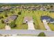 Aerial view of a well-maintained property with lush landscaping, and neighborhood at 13953 Thoroughbred Dr, Dade City, FL 33525