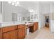 Bright bathroom featuring double sinks, vanity, and walk-in closet at 13953 Thoroughbred Dr, Dade City, FL 33525