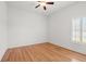 Empty bedroom with hardwood floors, fan, and window at 13953 Thoroughbred Dr, Dade City, FL 33525
