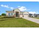 Charming single-story home with a manicured lawn, stone accents, and a three-car garage at 13953 Thoroughbred Dr, Dade City, FL 33525