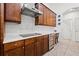Modern kitchen featuring stainless steel appliances, dark wood cabinets and an overhead vent at 13953 Thoroughbred Dr, Dade City, FL 33525
