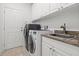 Well-equipped laundry room with modern washer, dryer, sink, and ample storage cabinets at 13953 Thoroughbred Dr, Dade City, FL 33525