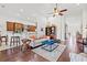 Open-concept living area with hardwood floors, a breakfast bar, and views into the kitchen and dining spaces at 13953 Thoroughbred Dr, Dade City, FL 33525