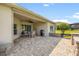 Covered patio featuring an outdoor kitchen, ceiling fan, and comfortable seating area at 13953 Thoroughbred Dr, Dade City, FL 33525