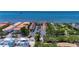 Aerial view highlighting the complex, parking, mature trees, and waterfront views at 1420 Bayshore Blvd # 409, Dunedin, FL 34698