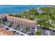 Aerial view of condo building with beautiful water views, parking, and tropical landscaping at 1420 Bayshore Blvd # 409, Dunedin, FL 34698