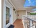 Condo balcony with white railing and view looking towards the front door, plus exterior light fixture at 1420 Bayshore Blvd # 409, Dunedin, FL 34698