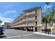 The exterior of a condo building showcasing multiple balconies and covered parking area with palm trees surrounding at 1420 Bayshore Blvd # 409, Dunedin, FL 34698