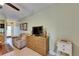 Open living space with tiled floors, a woven dresser, and a comfortable floral armchair at 1420 Bayshore Blvd # 409, Dunedin, FL 34698