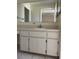 Bathroom vanity with a full wall length mirror and storage cabinets at 1512 Chateaux De Ville Ct, Clearwater, FL 33764