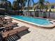 Community pool deck with several lounge chairs and palm trees at 1512 Chateaux De Ville Ct, Clearwater, FL 33764