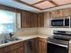Efficient kitchen layout with stainless steel appliances and wood cabinetry at 1512 Chateaux De Ville Ct, Clearwater, FL 33764